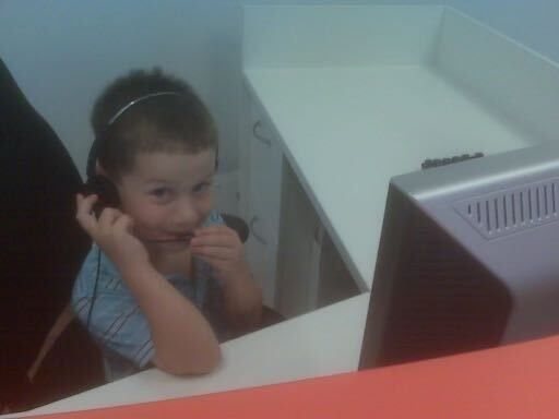 ryan as a young kid wearing a headset at a desk in his dad's first call center